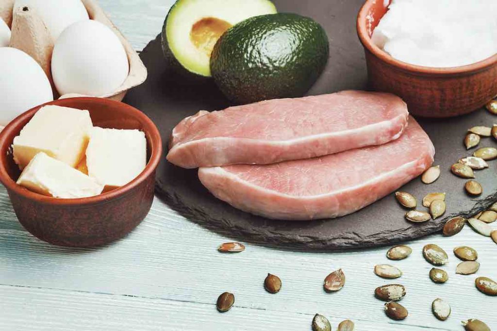 Concept of ketogenic diet. Dietary food on light table | Nutrigility Ketogenic diet, fad diet foods including butter, eggs, avocado, meat, and coconut oil
